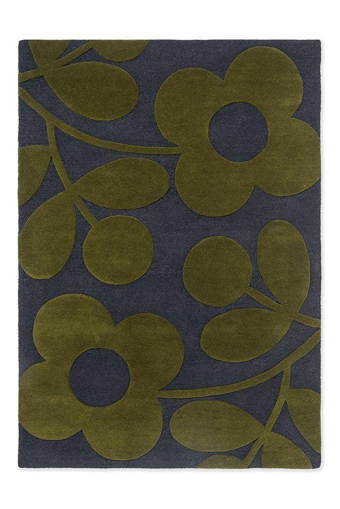 A rectangular Orla Kiely wool rug featuring a floral pattern with large green and black flowers on a paprika red background.
