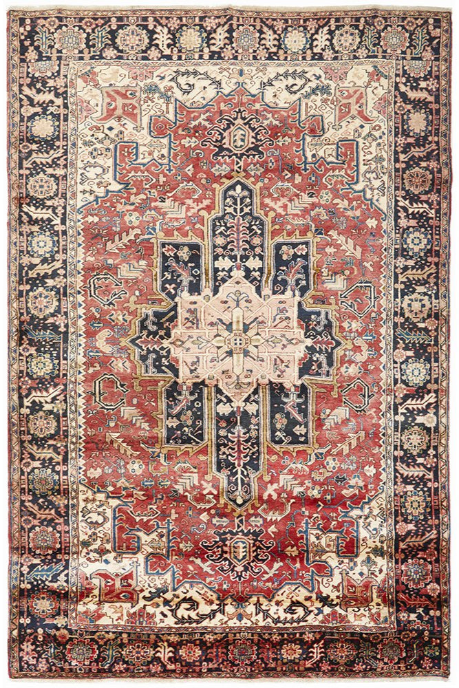 A Heriz hand knotted Persian rug featuring a geometric medallion design with ivory highlights and a dense pile.