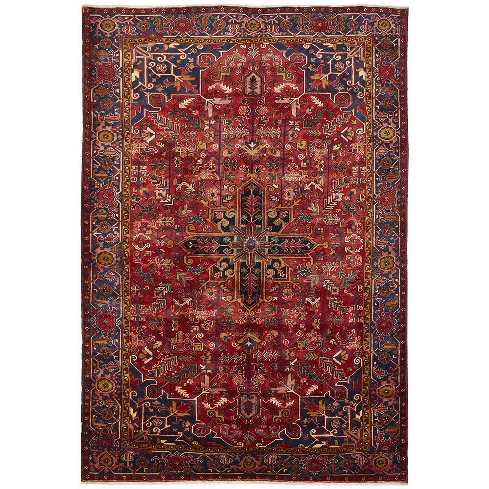 A Heriz hand knotted Persian rug with a geometric pattern featuring a large central medallion and ivory highlights, predominantly in red and blue colors.
