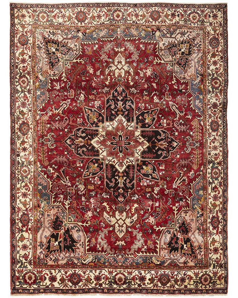 A large, hand knotted Persian rug with a geometric medallion design and ivory highlights, predominantly red in color, with a dense pile.
