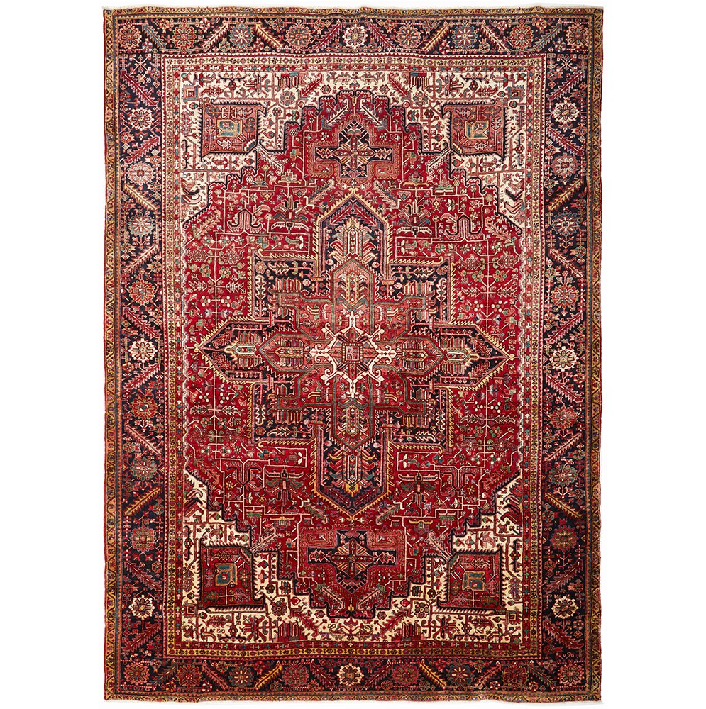 A large, hand knotted Persian rug with a geometric medallion design and ivory highlights, predominantly red and dark blue colors.
