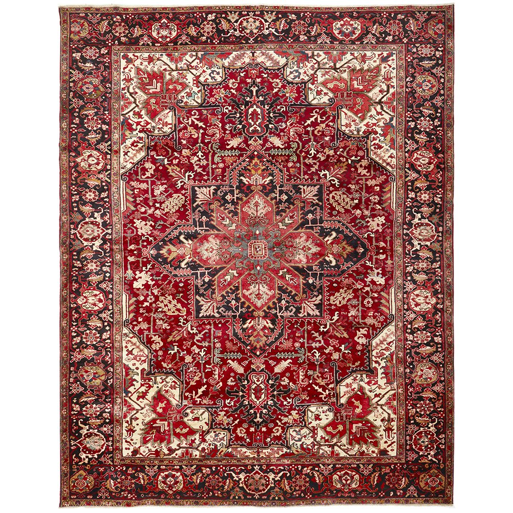 A Heriz hand knotted Persian rug with a geometric medallion design and ivory highlights, predominantly red color, with a dense pattern.