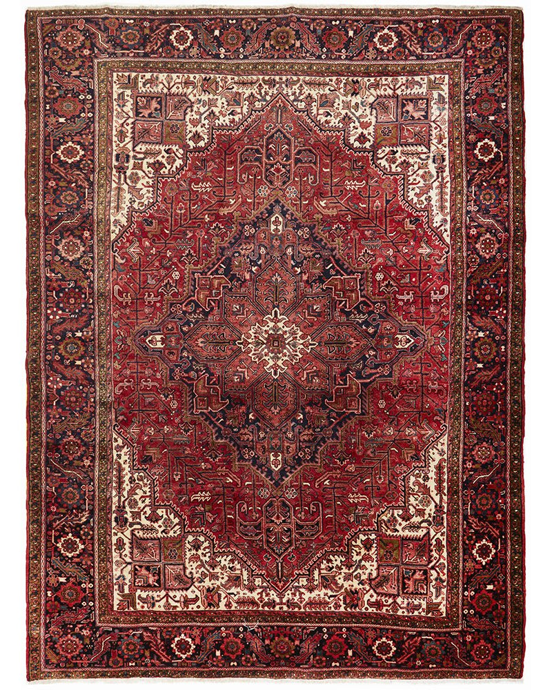 A large, hand knotted Persian rug with a geometric medallion design and ivory highlights, predominantly in red and blue colors.
