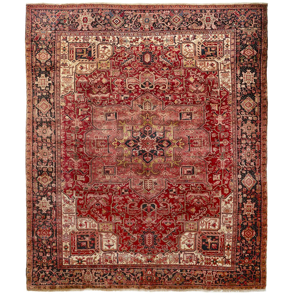 A large, hand knotted Persian rug with a geometric medallion design and ivory highlights, predominantly red and multicolored patterns.