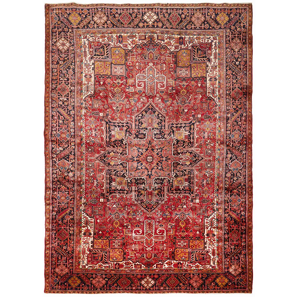 A Heriz hand knotted Persian rug with a geometric medallion design and ivory highlights, predominantly red color, with intricate patterns.
